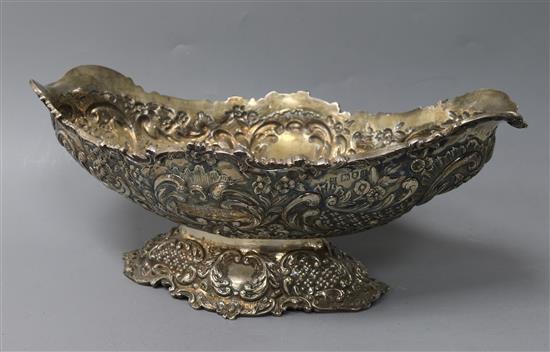 A late Victorian embossed silver oval pedestal fruit bowl, Goldsmiths & Silversmiths, London, 1899, 23.5 oz.